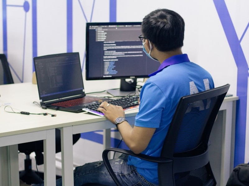 boy in blue t-shirt sitting on black office rolling chair in front of computer
