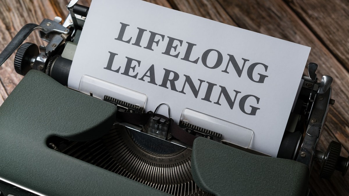 a close up of a typewriter with a paper that says lifelong learning
