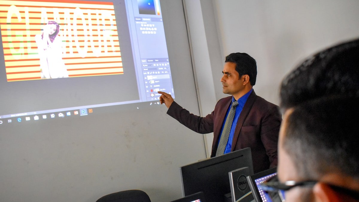 a man standing in front of a projector screen giving a presentation