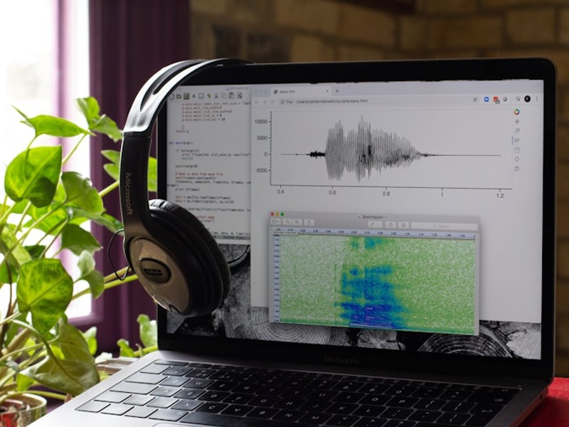 a laptop computer with headphones on top of it